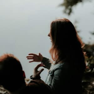 Ethics Explainer: Woman gesturing, discussing tolerance. Outdoor setting, possibly explaining a viewpoint, promoting understanding and ethical discussion.