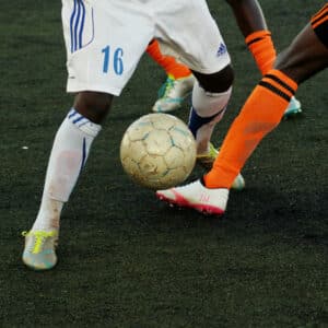 Soccer players compete for the ball. Focus on sportswashing, money, and politics corrupting sport. Soccer corruption and politics.