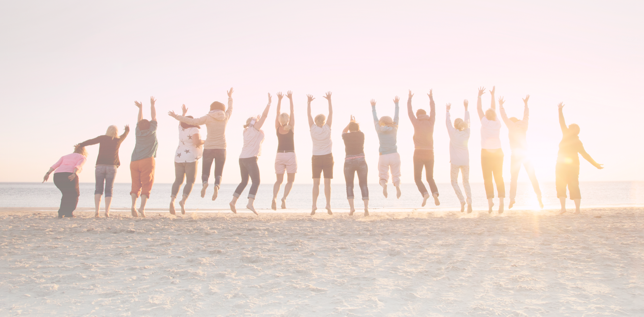 Group of people jumping on a beach at sunset, arms raised. Beachgoers celebrate with a jump, enjoying the sun and sand. Coastal fun and friendship.