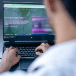 Using AI for work: Person using ChatGPT on laptop. Ethical AI use concept.