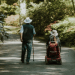 Elderly care: Man with cane and woman in wheelchair on path. Duties of care involve finding balance in providing care.