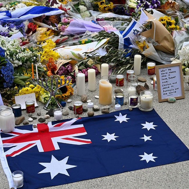 Memorial site for the Bondi massacre, Australia. Flowers, candles, Israeli flag, & Australian flag for national response. Condolences.