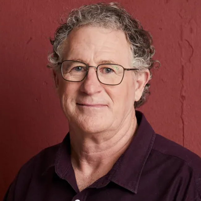 Headshot of a smiling man with glasses, discussing the ethics of forgiveness in an article about forgiveness and morality.