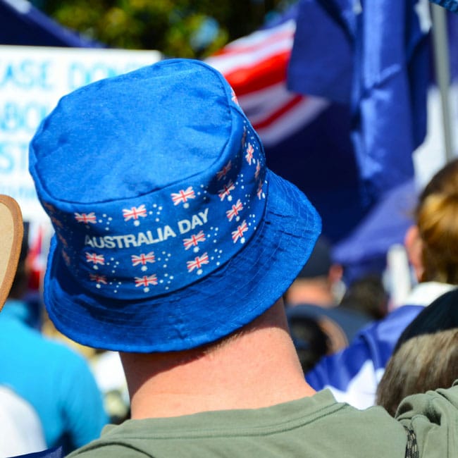 Aussie pride: Blue bucket hat with Australian flags & Australia Day text. Loving your country is showing patriotism at national events.