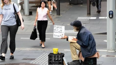 Common-Ground image: Man begs on city street, holding a sign that says