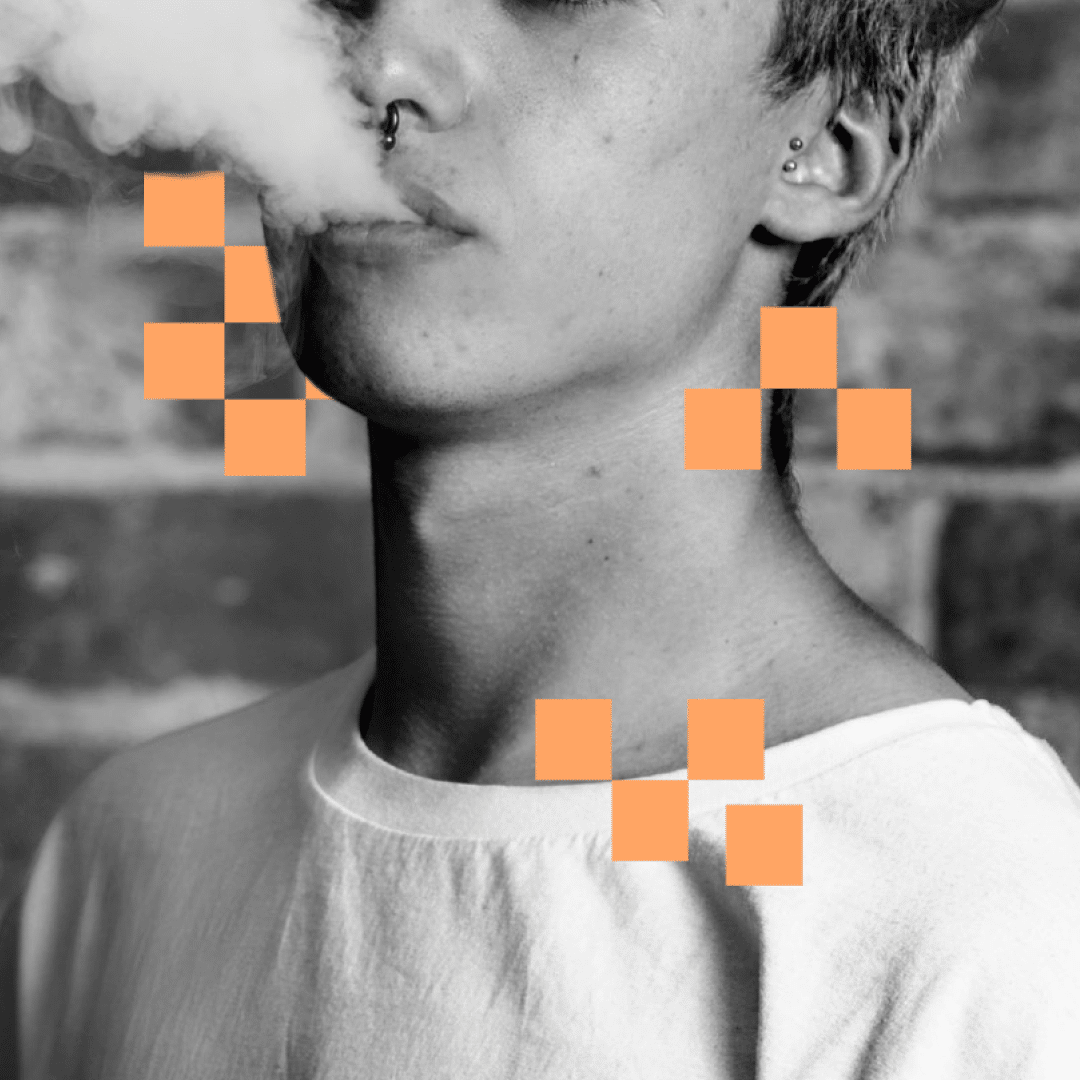 Monochrome image about the ethics of bans: Person exhaling smoke, with nose ring and ear piercings, against a brick wall, with orange pixelation.