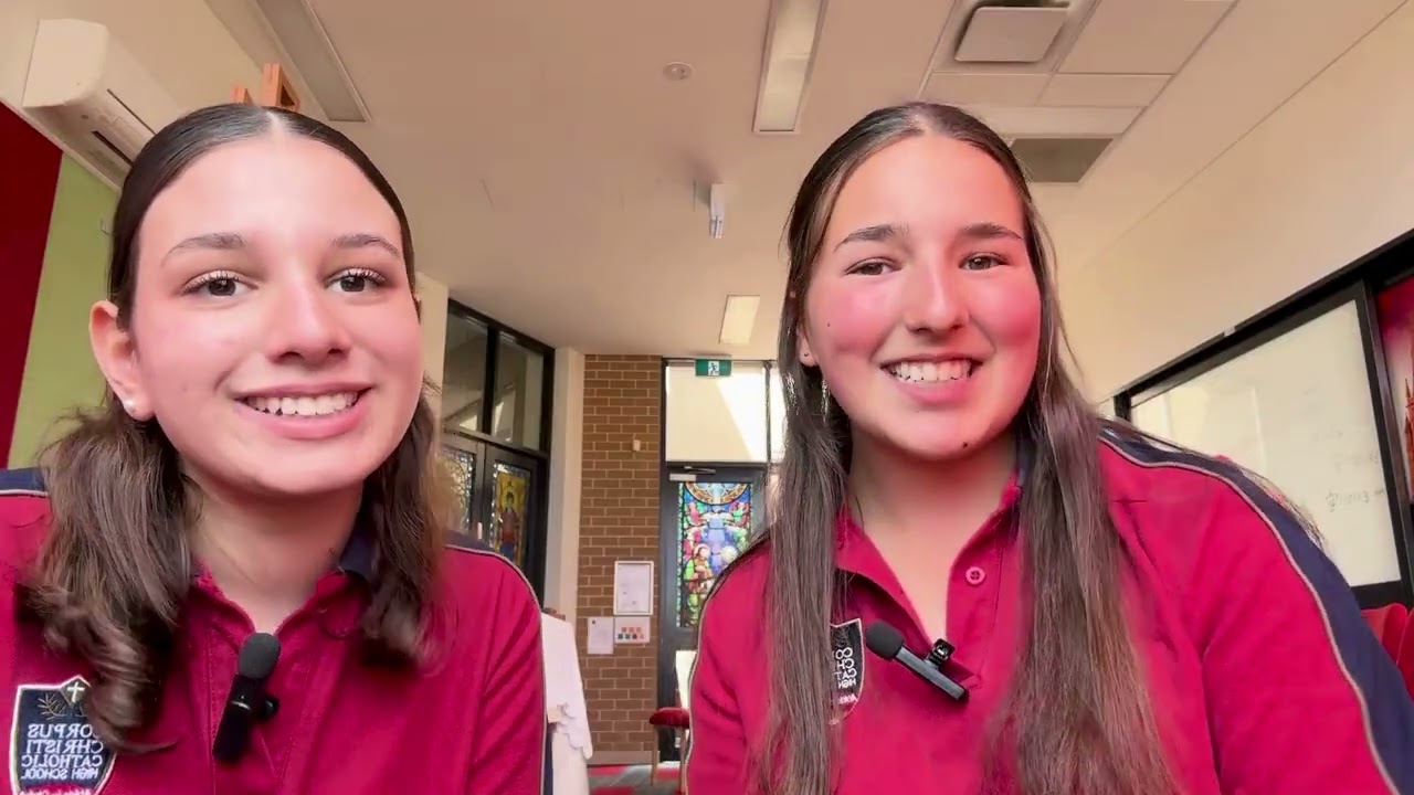 Two smiling students discuss Religious Discrimination in a Common Ground program video. They are wearing school uniforms and lapel microphones.