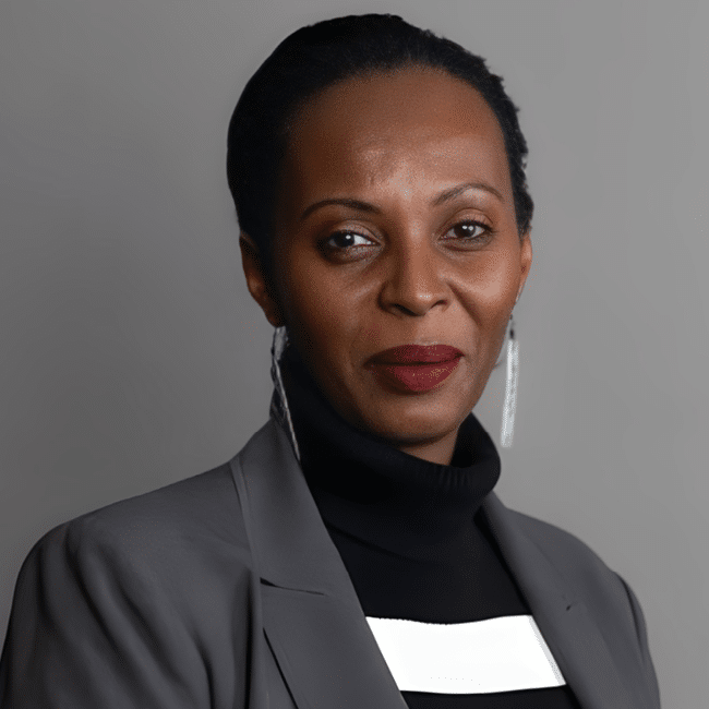 Carine Kaneza Nantulya, discussing the attention economy of suffering, wears a gray jacket and black turtleneck. Face close-up.