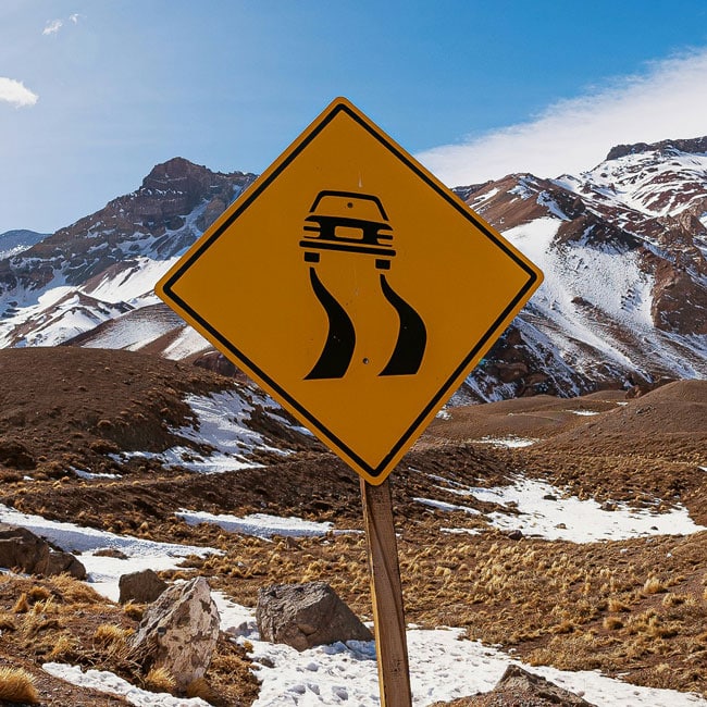 Yellow slippery road sign warns of 'value drift' principle shifts, with snowy mountains showcasing organizational risks, and potential AI impact.