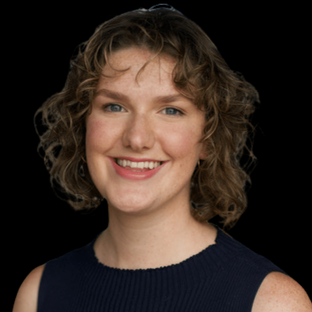 Close-up portrait of Lauren Bennett, fair skin, curly blonde hair, blue eyes, smiling warmly at the camera against a black background.